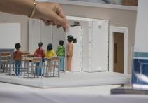 Plastic model of a classroom with a teacher and students.